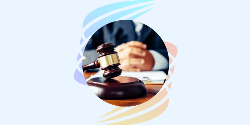 Richterhammer auf Tisch vor einer Person im Anzug – Symbolbild für rechtliche Kontrolle und Gesetzesanwendung